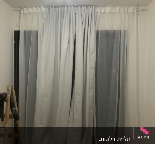 סולם עץ ליד וילון לבן מותקן